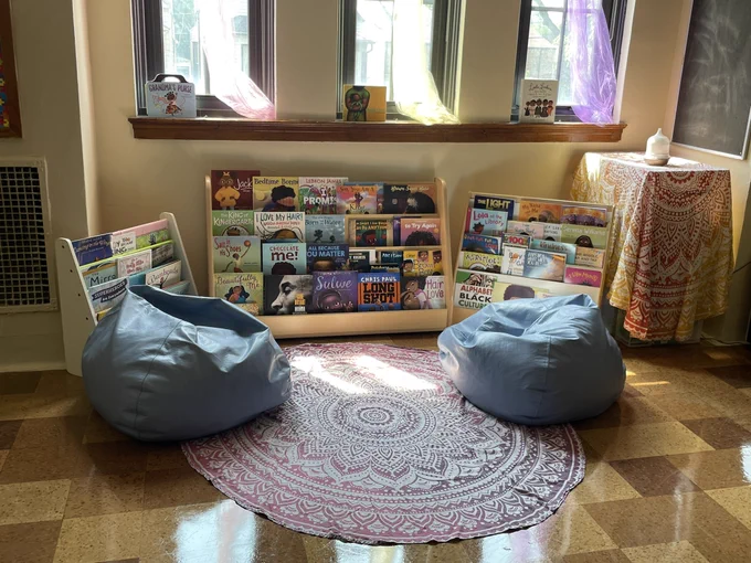 A reading nook in a classroom with two blue beanbags and a book shelf filled with culturally responsive books