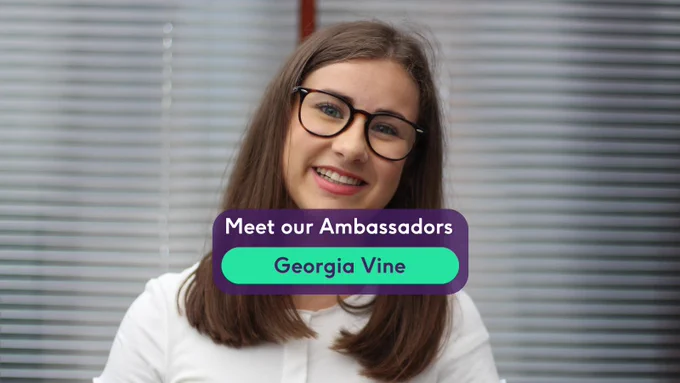 Georgia is a white woman with short straight brown hair, she wears frown rounded glasses and a white blouse, she is smiling toward the camera. A purple text box reads "Meet our Ambassador Georgia Vine"