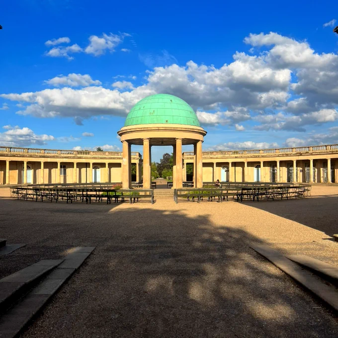 Eaton Park in Norwich, showing a central bandstand with rows of seats around it amidst a blue sky