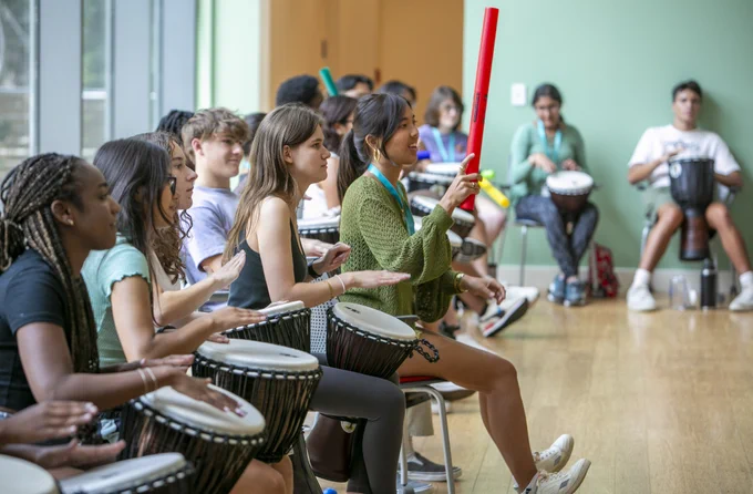 Students participate in a drum circle