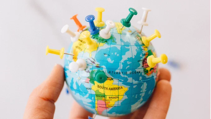 Image of a globe with pins in various locations.