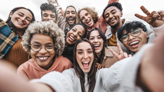 A group of multicultural young adults taking a selfie.