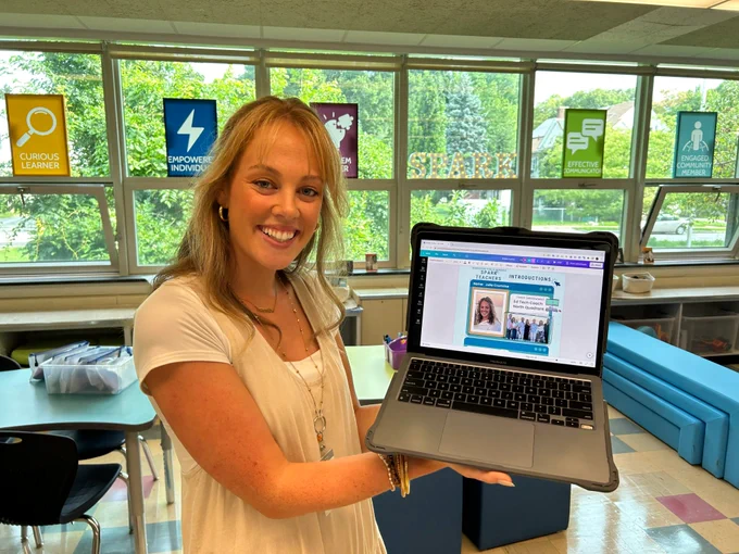 Julia Crumrine holds a laptop with an image she designed