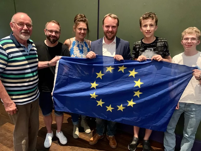 Gruppenbild von Mitgliedern der Grünen Leverkusen mit dem Euroabgeordneten Daniel Freund und der Europafahne