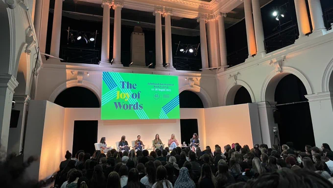 From left to right: Dr Melanie R Bold, Louise Finch, Cynthia So, Katherine Webber, Laura Steven and Nadia Mikail. 
A YA Book Prize panel event at the Edinburgh International Book Festival in a large room with colonnades and arches.