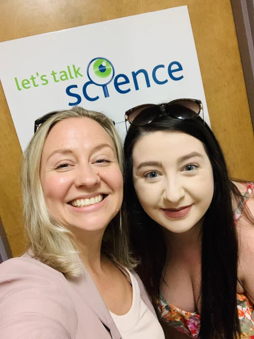 Selfie of Samantha and Toni-Marie with Let’s Talk Science logo in the background