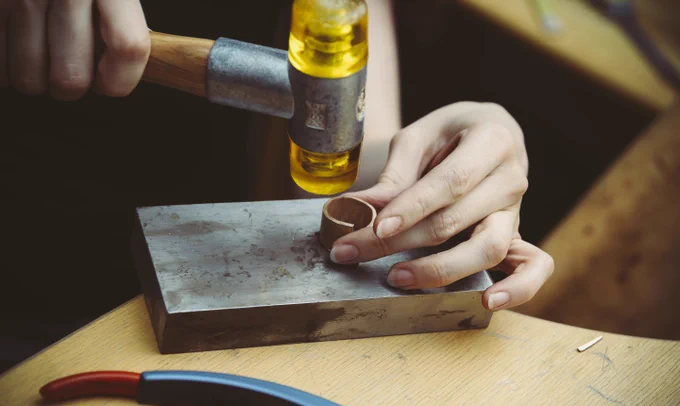 Person hammering a ring