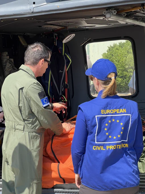 A firefighting pilot and a representative of the EU Civil Protection seen from the back.