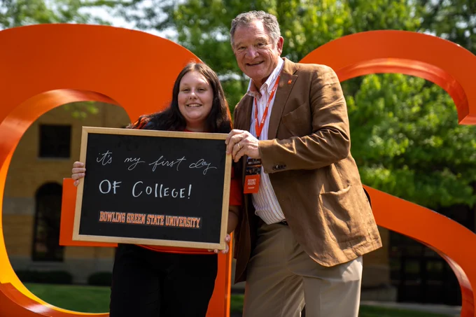 BGSU President takes first day of college photo with student in front of orange letters