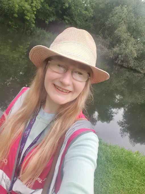 Me by a river wearing a pink hi-vis park run jacket.