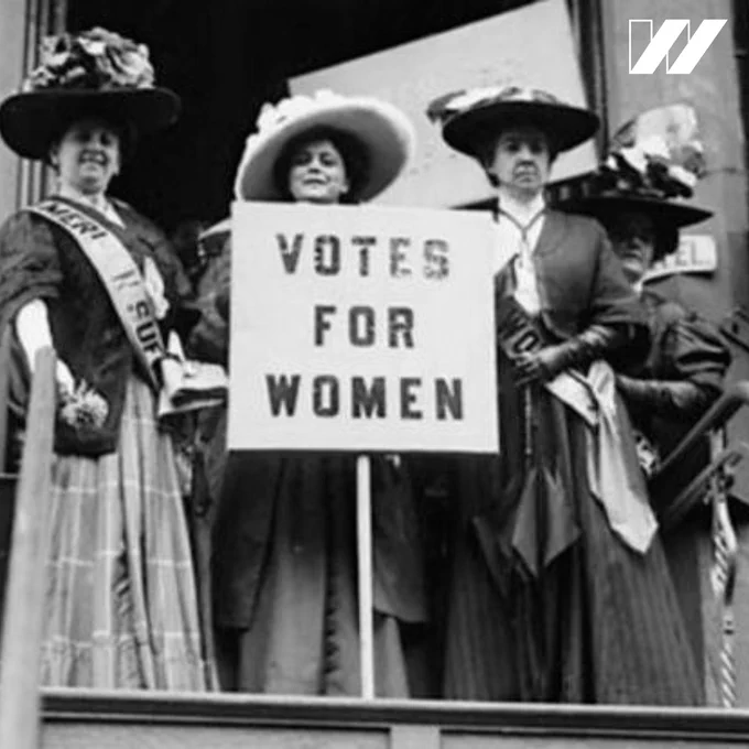 An image of three women holding a sign that says “Votes for women.” There is a white “w” U S O W in the top right corner. 