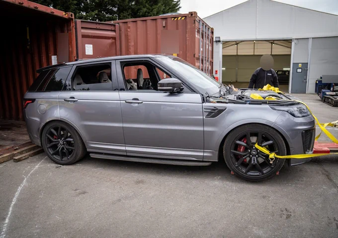 The Range Rover is removed from a shipping container.