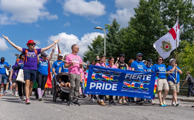 CSC staff in Pride Parade, wearing T-shirts, and holding a banner that reads: "Correctional Service Canada, CSC Pride."