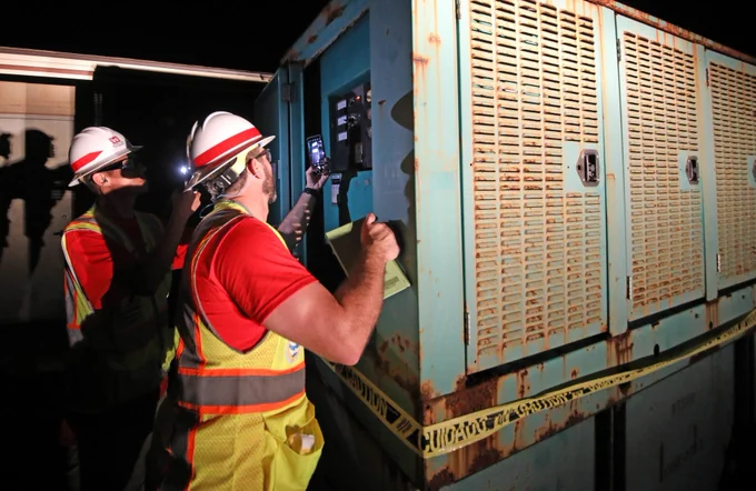 Kenny Kwan and Jon Runnels work on a generator