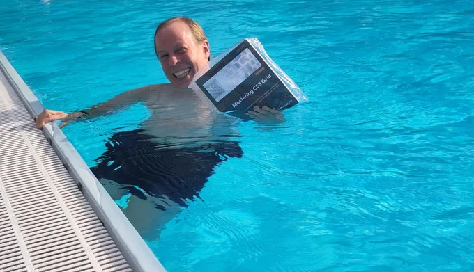 Me, holding my book while being in a swimming pool. The book is partially submerged.