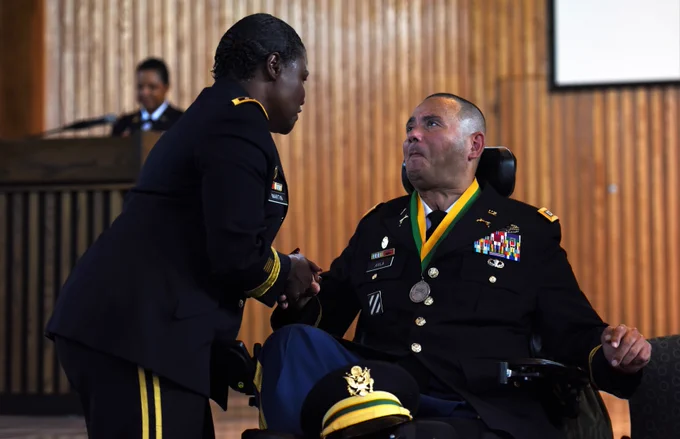 Lieutenant General Donna Martin presents Captain Luis Avila the Order of the Marechausse silver award.