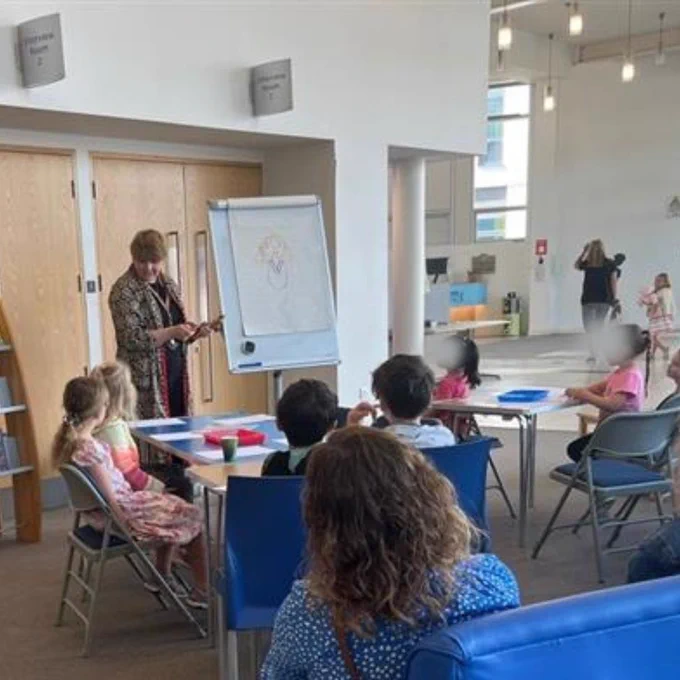 sharon drawing a picture on a flipchart, surrounded by her adoring fans