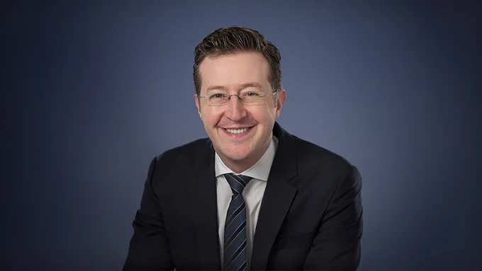 Image of smiling male researcher in business casual.
