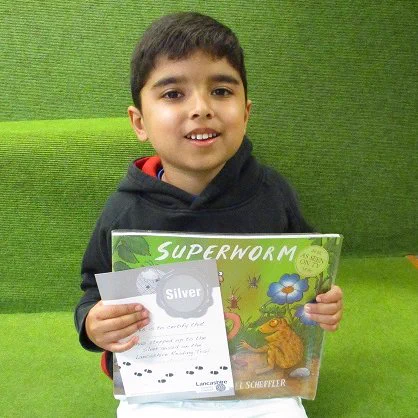 child with certificate and superworm book