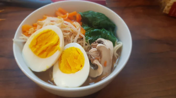 Ramen in Erdnuss-Soße mit Ei, Spinat, Karotten und Pilzen 