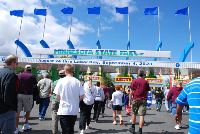 A picutre of people walking toward the main gates of the Minnesota State Fair.