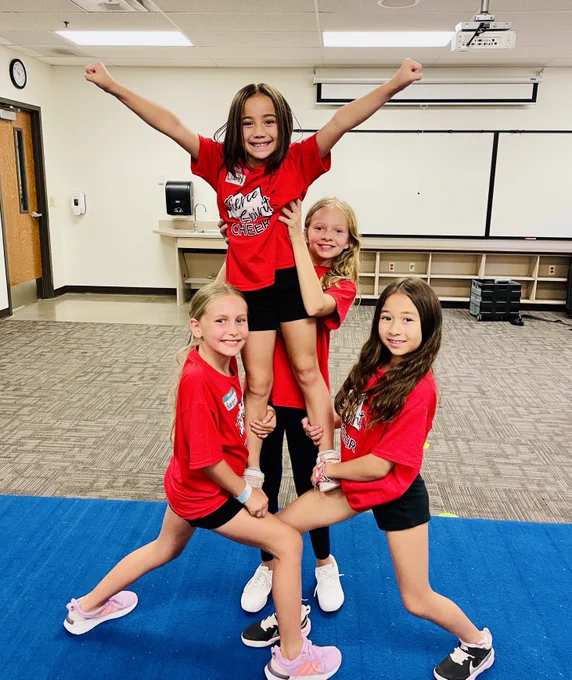 Image of 4 young girls performing a cheer stunt