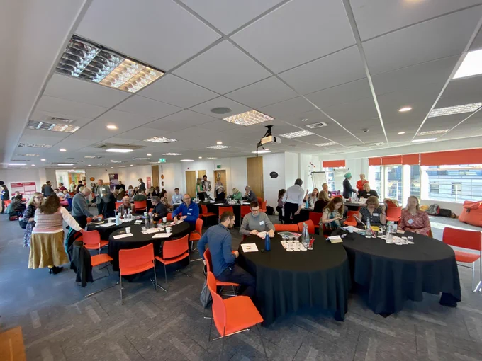 Members of the Yorkshire & Humber Climate Commission assemble at tables in the meeting space