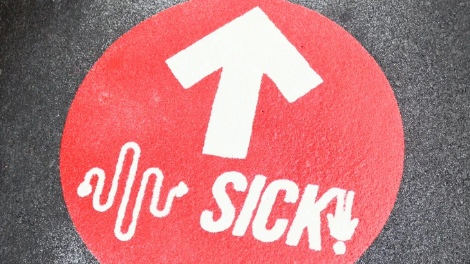 Image three shows a close up image of a red floor marker for the SICK! Soundpaths project against a dark back concrete background.