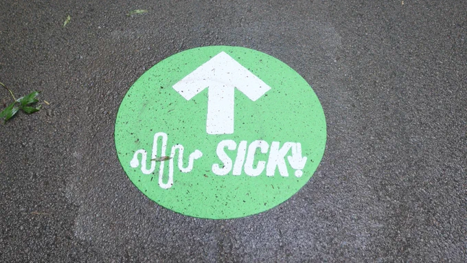 Image four shows a close up image of a green floor marker for the SICK! Soundpaths project against a dark back concrete background