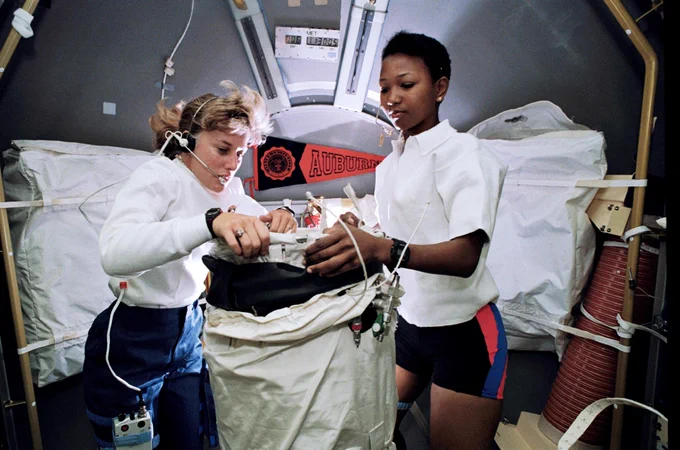 Astronauts N. Jan Davis (left) and Mae C. Jemison, STS-47 mission specialists, prepare to deploy the Lower Body Negative Pressure (LBNP) apparatus in the Spacelab Module aboard Space Shuttle Endeavour.