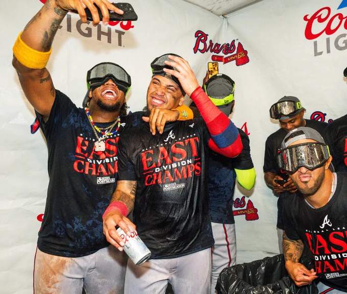 Ronald Acuña Jr., Orlando Arcia and Eddie Rosario pose for pictures during tonight’s clubhouse celebration.