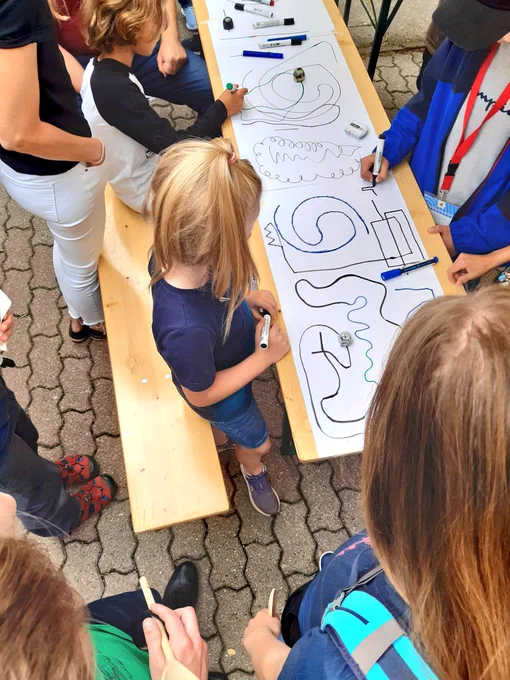 Kinder malen eine Ozobot-Strecke