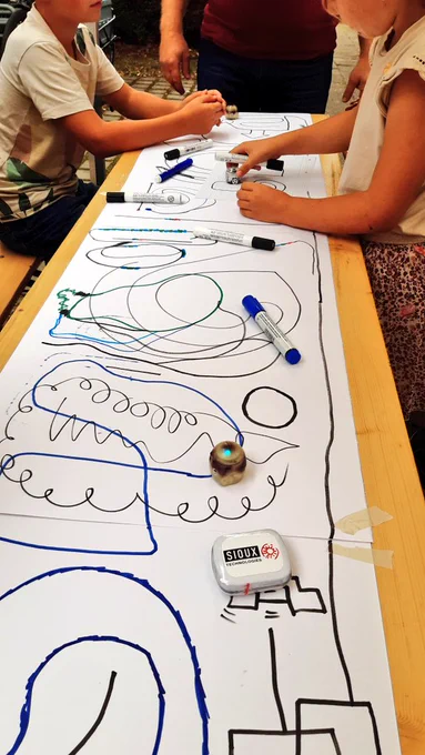 Ein Ozobot fährt über die gemalte Strecke.