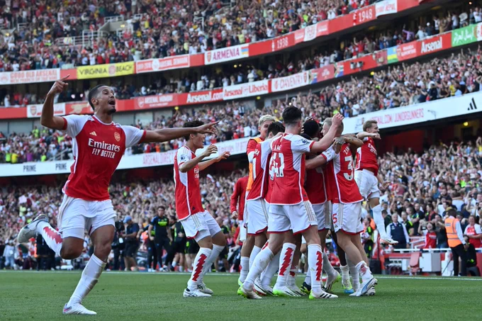 The Arsenal players celebrate Jesus' third goal.