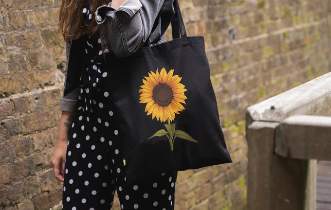 A black tote bag with a sunflower design