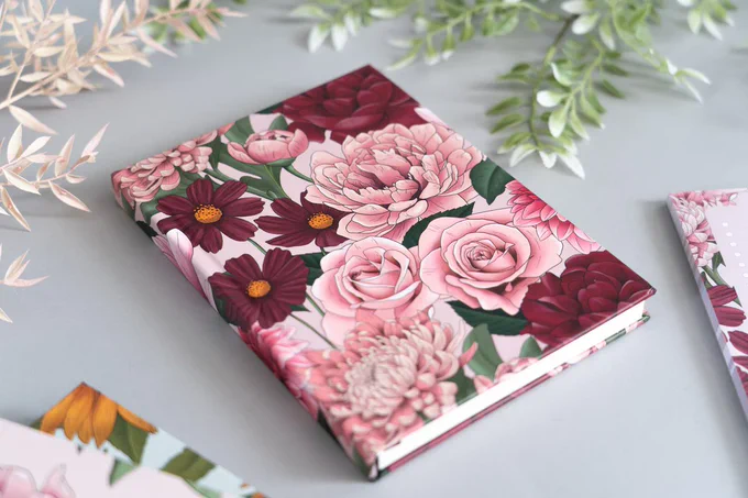 A hardback notebook with a pink floral design