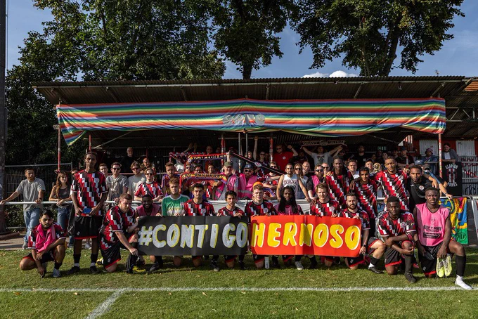CCFC men's first team holding a banner saying #CONTIGOHERMOSO at the Old Spotted Dog Ground