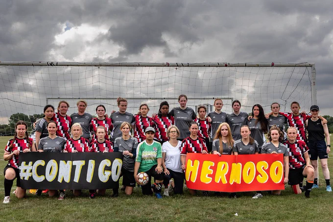 CCFC Open Access team and opposition holding a banner saying #CONTIGOHERMOSO at the Hackney Marshes