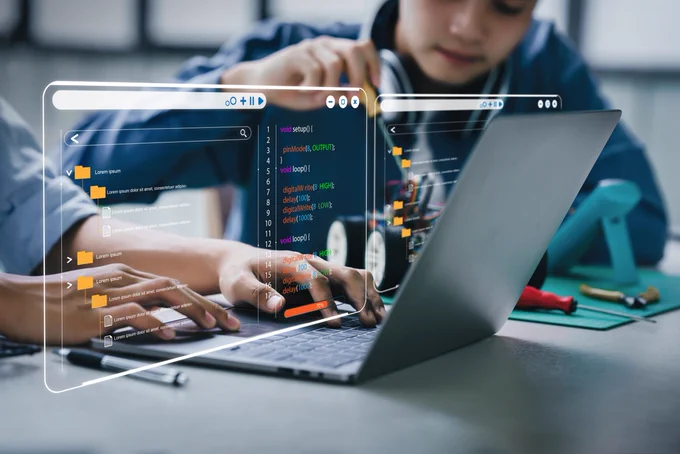 Students working with AI on computer.