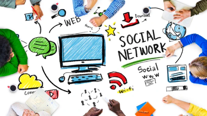 Image description: Five people are sitting around a table but you can only see their arms. The table is covered in various colourful illustrations of components of digital communications.