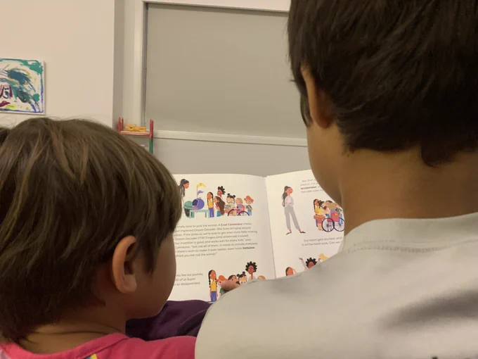 Two kids reading a book together