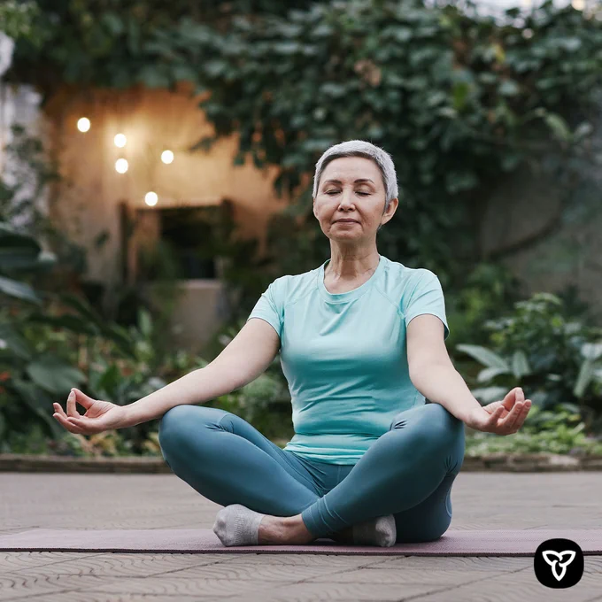 An older adult meditating.