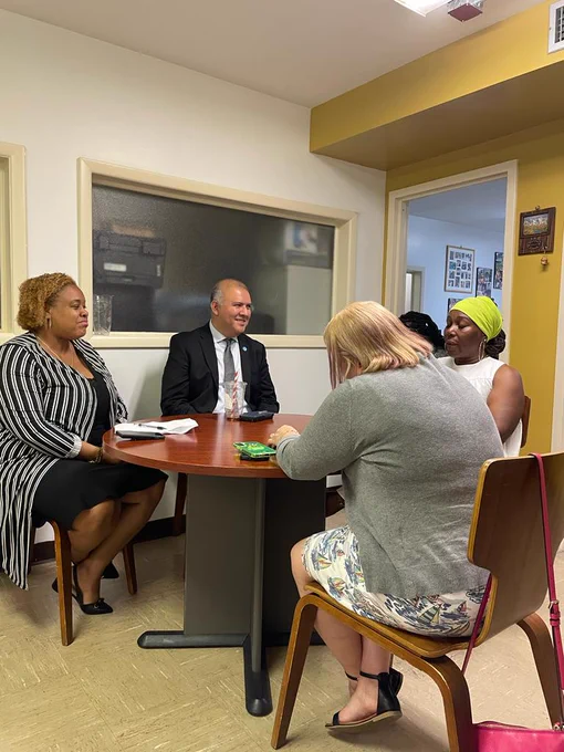 A group of people are sitting and talking together inside an office. 