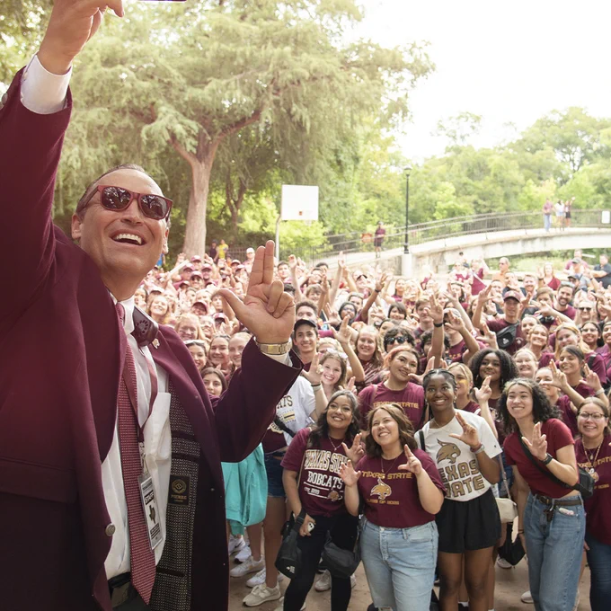 President Dr. Damphousse taking a picture with students.