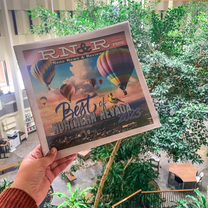 Photo one shows a hand holding the Best of Northern Nevada 2023 issue above some of the plant life at the Downtown Reno Library. 