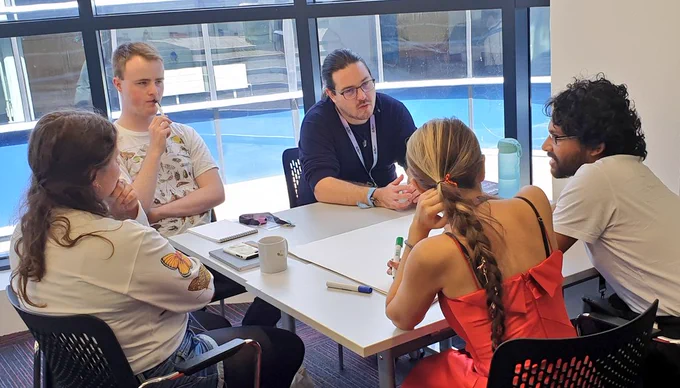 People chatting around a table at #Ento23 conference 