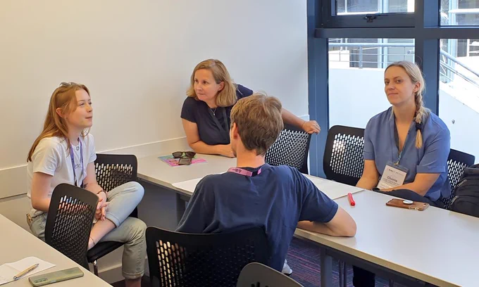 People chatting around a table at #Ento23 conference