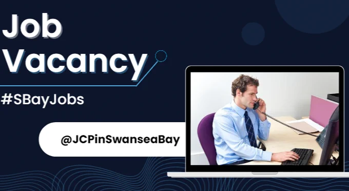 Image of an office worker sat at a desk while speaking on the telephone. Text saying job vacancy #SBayJobs @JCPinSwanseaBay