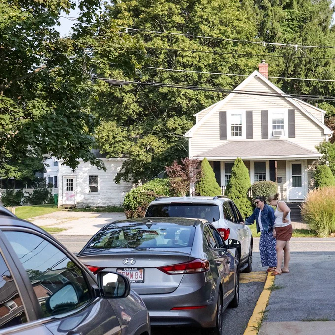 Ashland Preschool director Sara Davidson and a staff member talk to a caregiver in their car during drop-off on the first day of school of the 2023-2024 school year