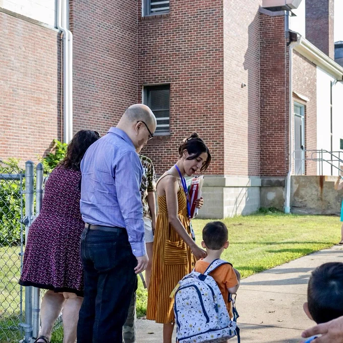 A teacher helps a parent escort a student for the first day of preschool of the 2023-2024 school year
